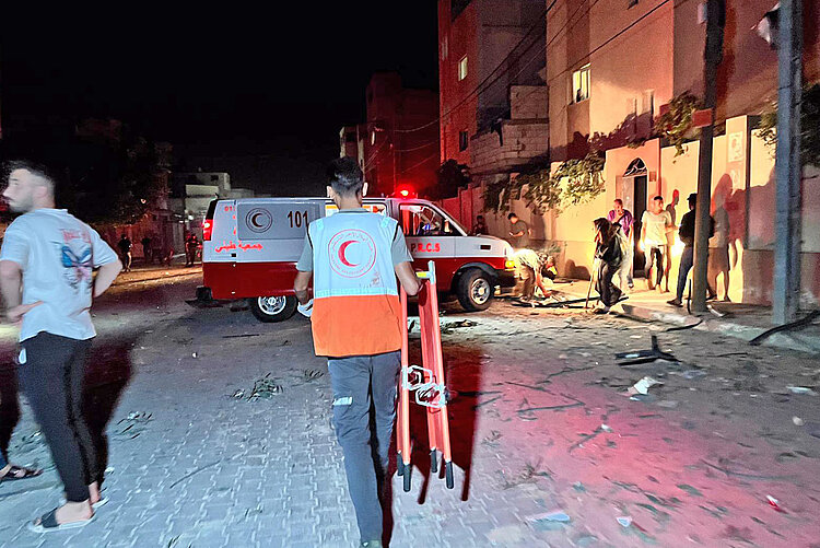 Helfer des Palästinesichen Roten Halbmondes vor Rettungswagen 
