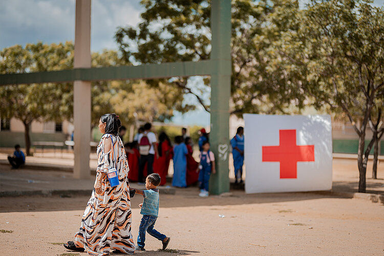 Rotes Kreuz in Kolumbien Frau und Kind vor Rotkreuz-Zeichen in Kolumbien