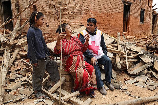 Rotkreuzhelfer hört Seniorin in Trümmern zu
