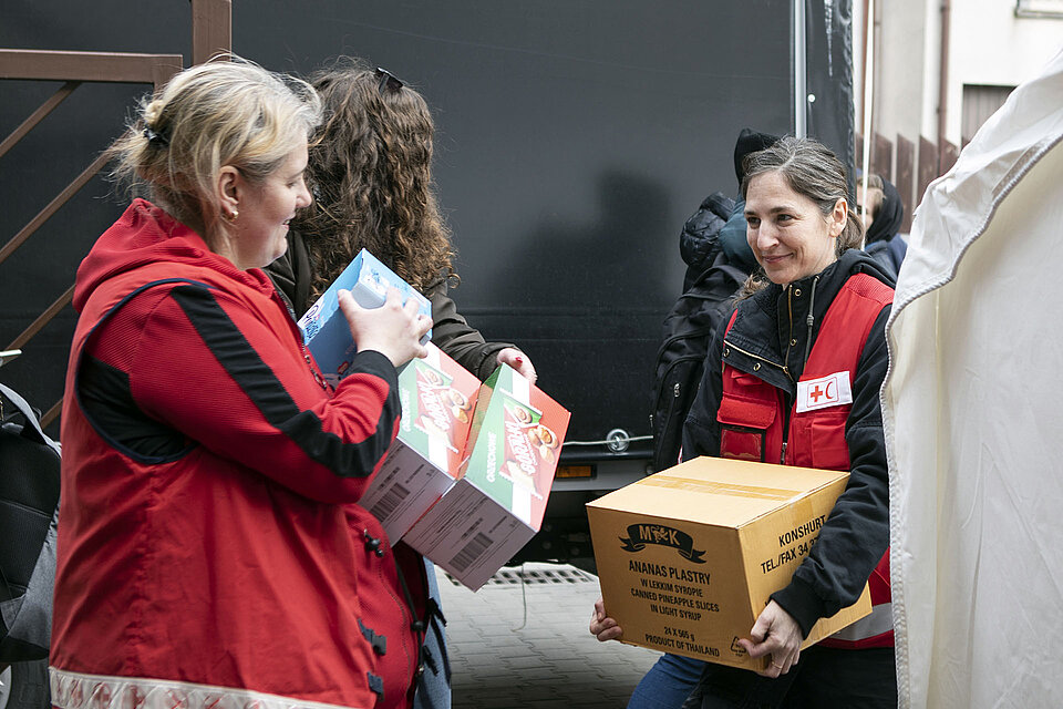 Rotkreuz-Helferinnen tragen Kartons