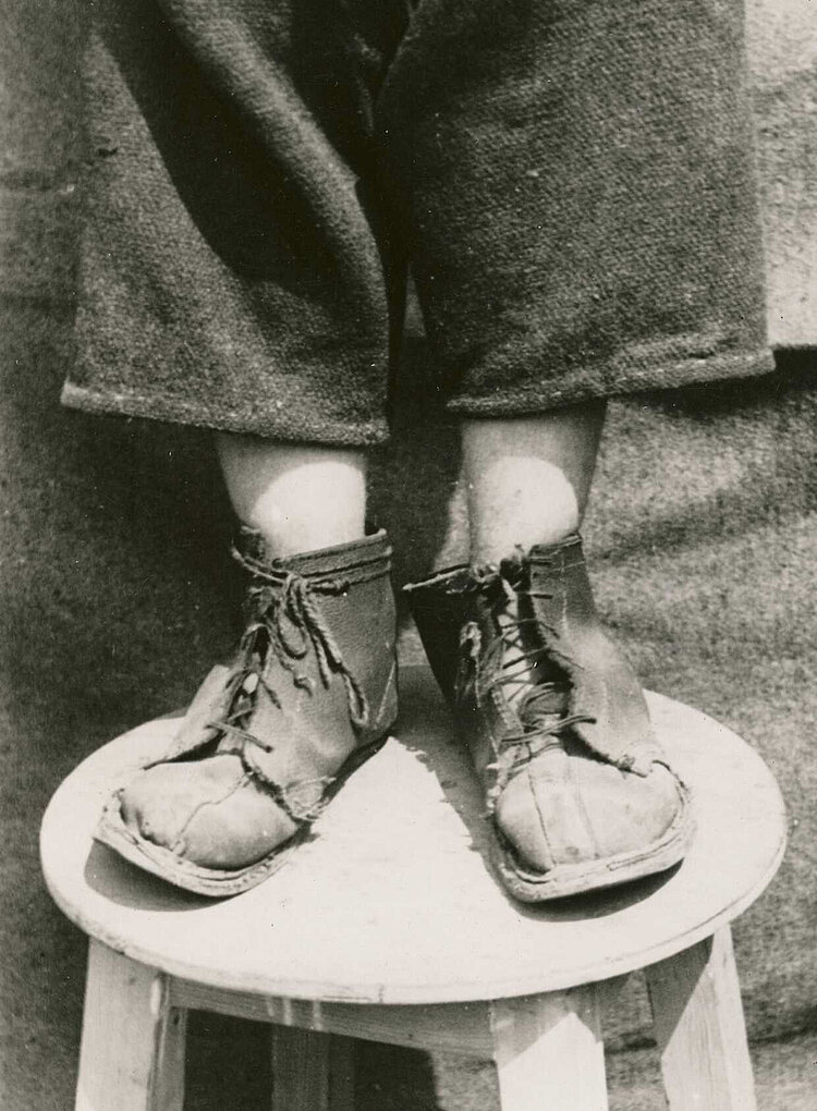 Nachkriegszeit in Deutschland: Ein Kind mit kaputten Schuhen im Lager Friedland (DRK)