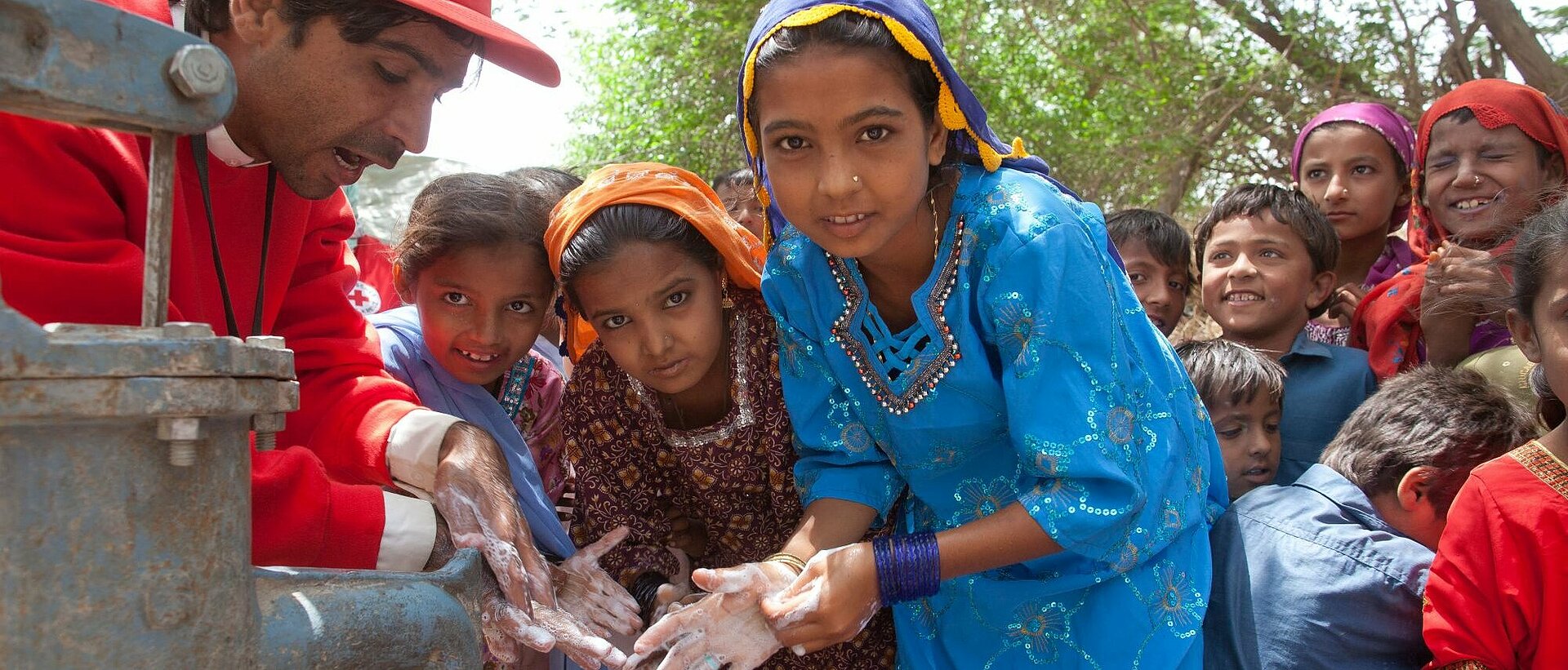 Mädchen und Rothalbmond-Helfer beim Händewaschen