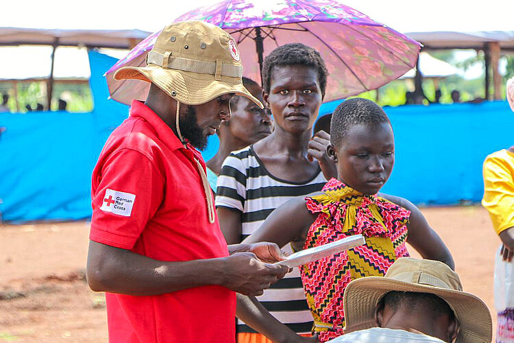 Rotkreuzler registriert Menschen bi Hilfsgüterverteilung