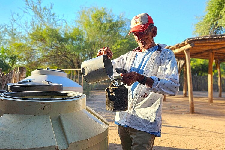 Wasserversorgung Mann schöpft Wasser aus Container