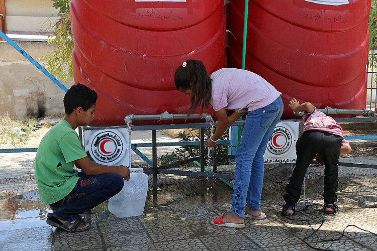 Syrische Kinder an Wasserstelle vom Roten Halbmond 