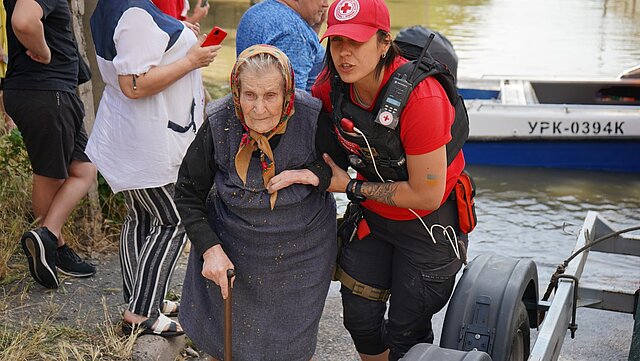 Eine Seniorin wird aus dem Überflutungsgebiet evakuiert.