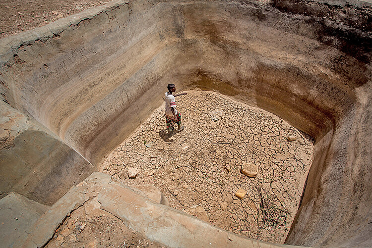 Junge und ausgetrocknete Wasserquelle in Somalia