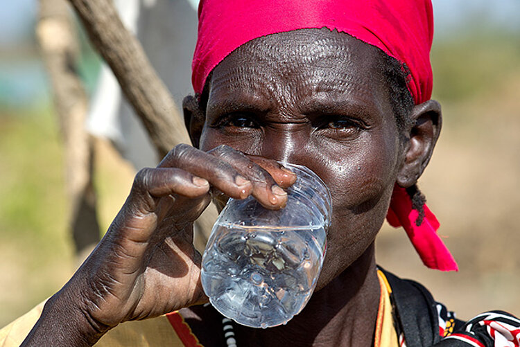 Südsudanesin trinkt ein Glas Wasser