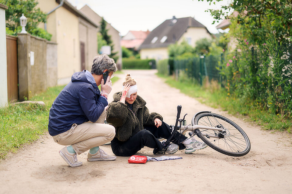 Mann telefoniert vor verletzter Fahrradfahrerin