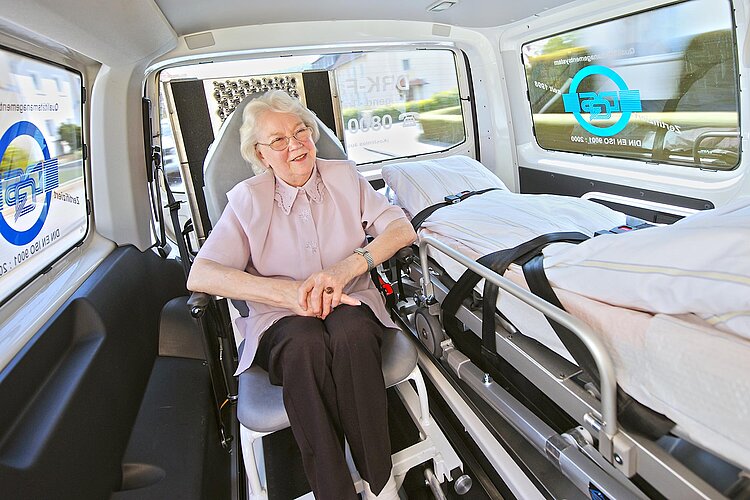 DRK-Fahrdienst Seniorin auf Transportstuhl in DRK-Fahrdienst-Fahrzeug
