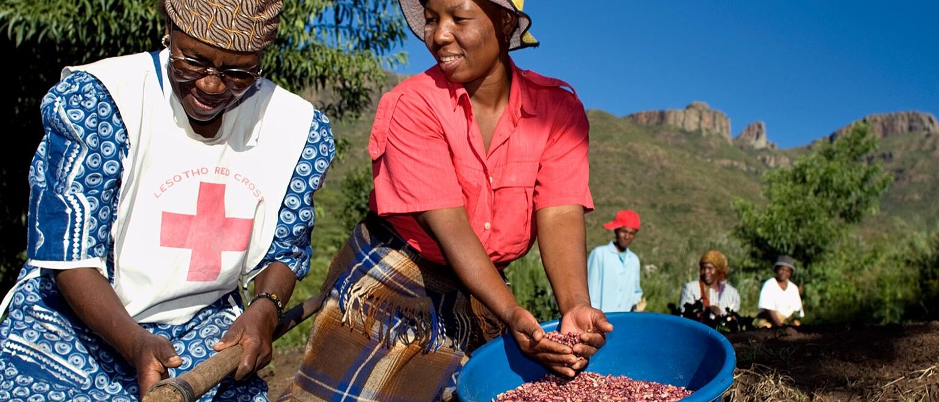 Zwei Frauen beim Ausbringen von Saatgut