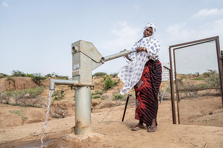 Afrikanische Frau nutzt Brunnen