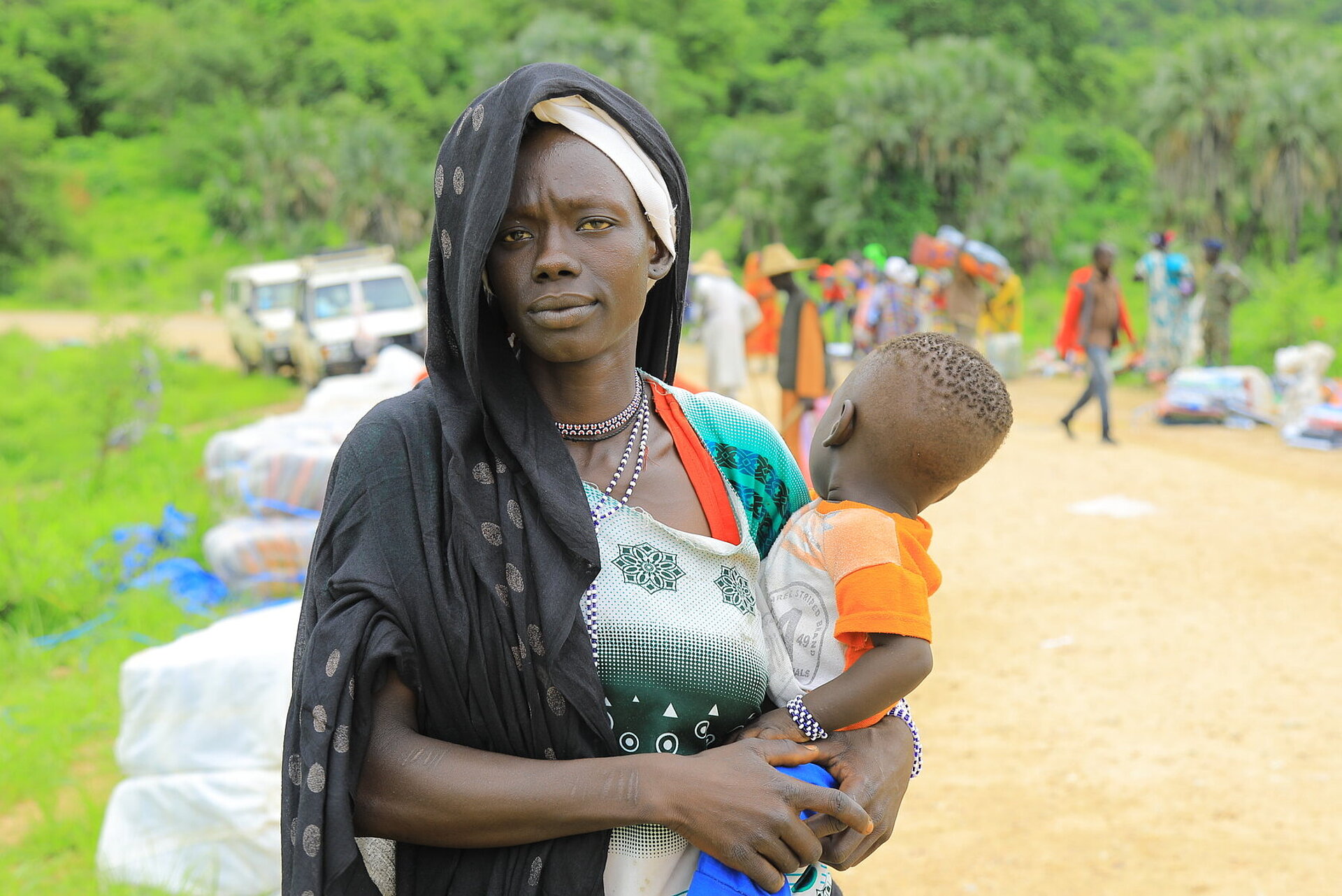 Verteilung von Hilfsgütern an Flüchtlinge aus dem Sudan durch das Äthiopische Rote Kreuz in den Orten Kurmuk und Guba an der Grenze zum Sudan. Frau mit ihrem kleinen Kind auf dem Arm