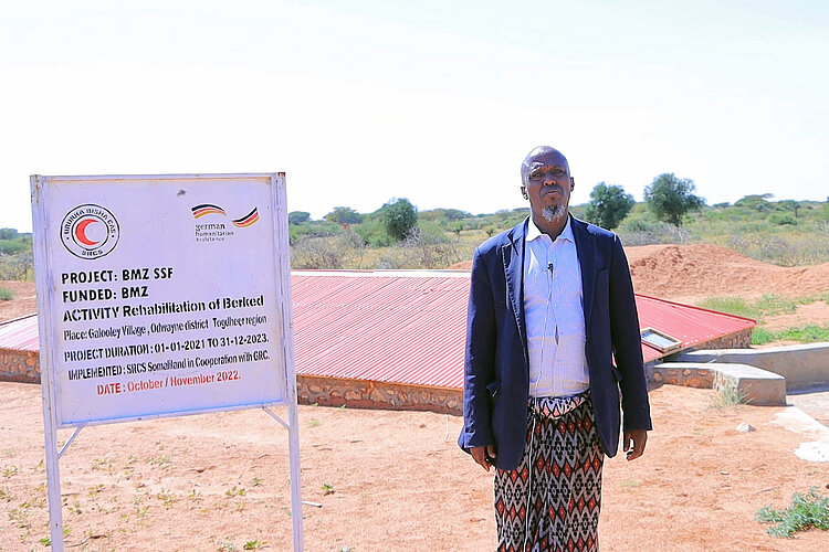 Mann vor Wasserreservoir und Projektschild