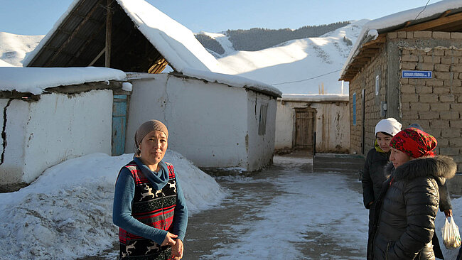 Kirgisin vor ihrem Haus im Winter