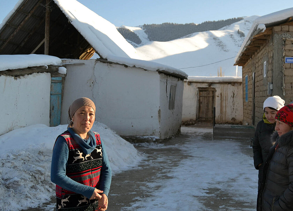 Kirgisin vor ihrem Haus im Winter