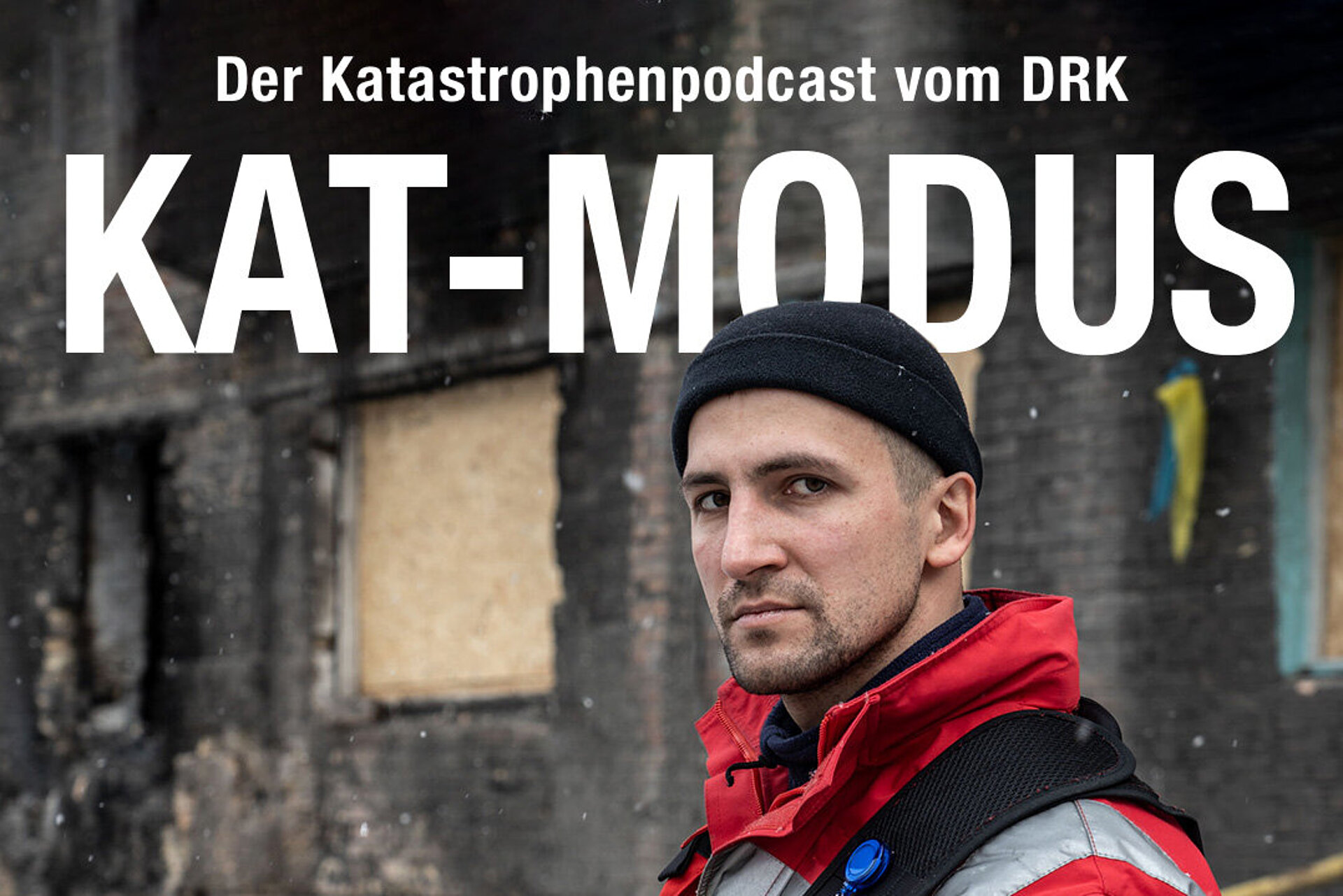 DRK Podcast KAT Modus Titelbild mit Rotkreuz-Mitarbeiter, welcher frontal in die Kamera schaut. Es steht in großer Schrift "Der Katastrophenpodcast vom DRK: KAT Modus" auf dem Bild.