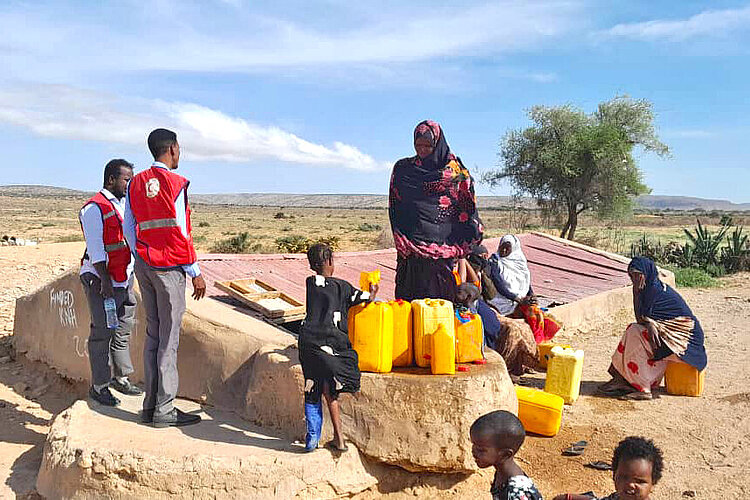 Somalia: Wasserreservoir Helfer und Familie an Wasserreservoir