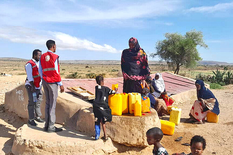 Helfer und Familie an Wasserreservoir