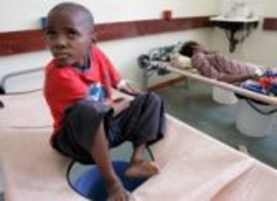 Simbabwe: Junge auf einem Krankenhausbett. Foto: Ein kleiner Junge sitzt auf einem Krankenhausbett.