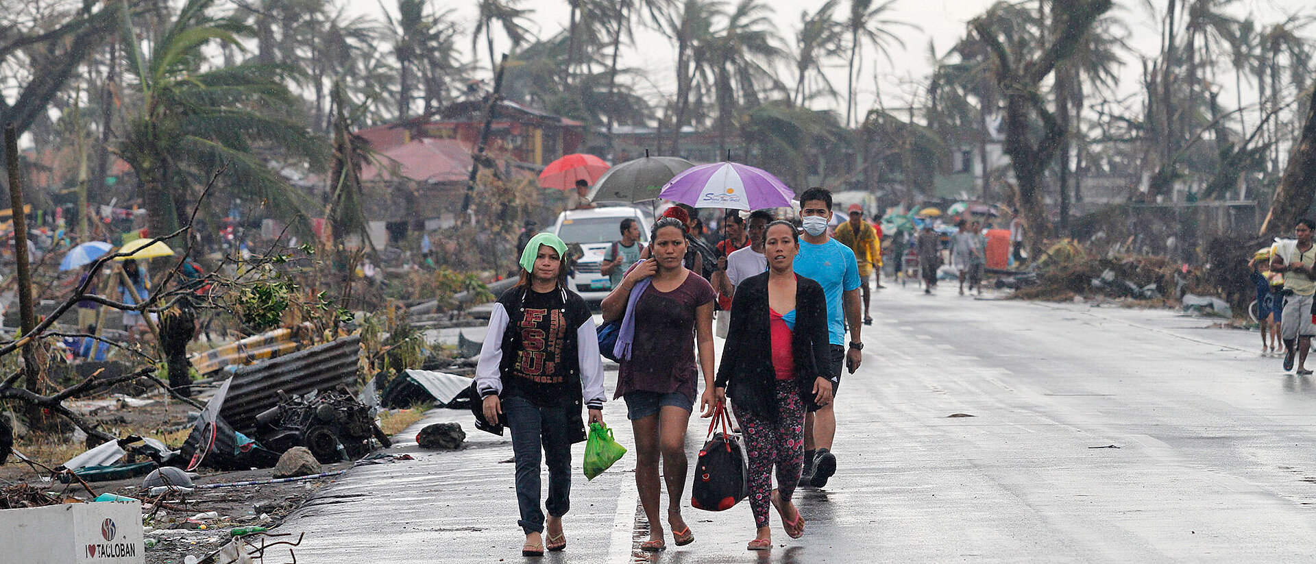 Menschen auf Straße bei Regen und Wind