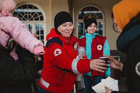 Helferinnen vom Polnischen Roten Kreuz verteilen Getränke auf dem Bahnhof von Lublin, wo viele Geflüchtete ankommen.