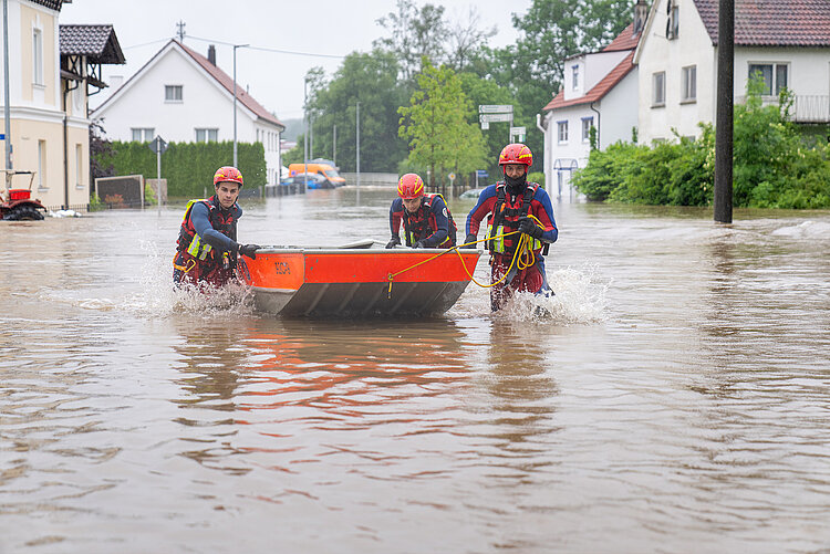 Einsatzteam mit Rettungsboot im Hochwasser 