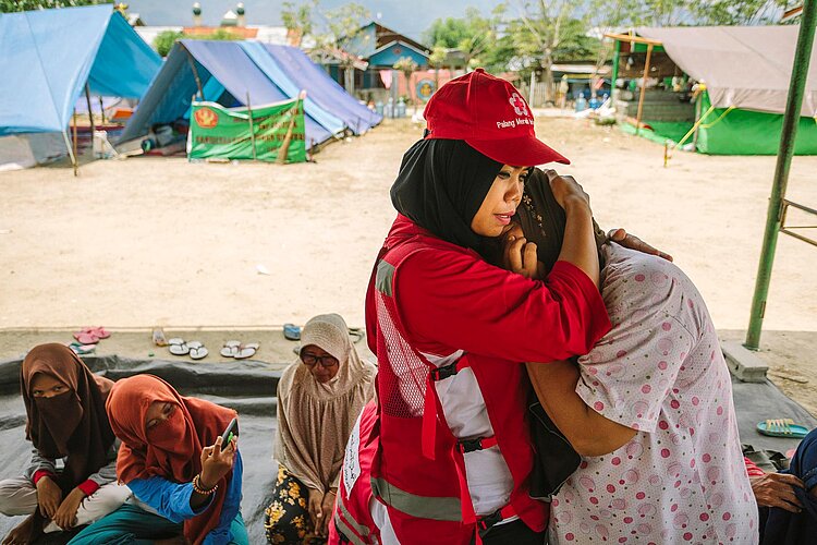 Psychosoziale Hilfe Rotkreuz-Helferin umarmt eine Frau