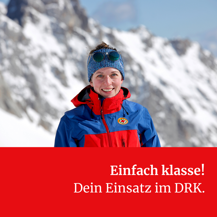 Tag des Ehrenamtes. Einfach klasse! Eine Frau in blau-roter Jacke der Bergwacht und mit blauer Mütze steht vor einem verschneiten Berg. Darunter stht "Einfach klasse! Dein Einsatz im DRK."