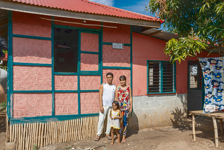 Foto: Philippinische Familie vor ihrem neu errichteten Haus