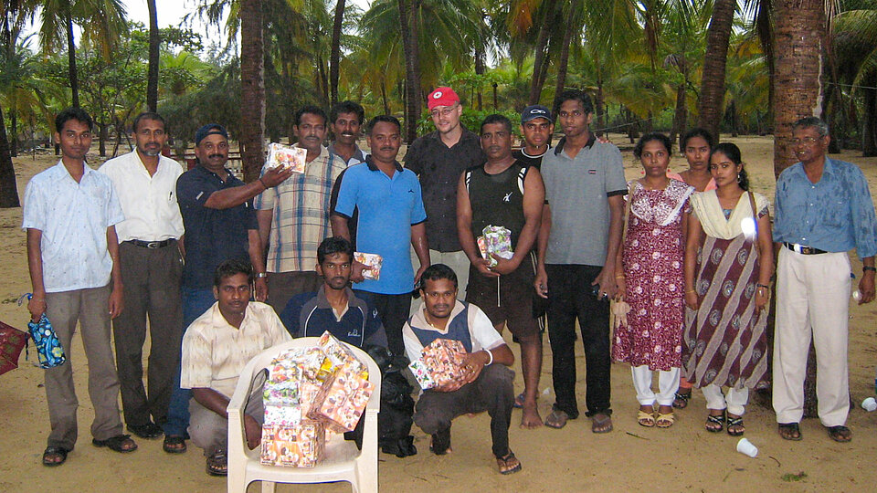 Eine Gruppe von Rotkreuzmitarbeitenden in Sri Lanka steht beim Gruppenfoto im Freien zusammen