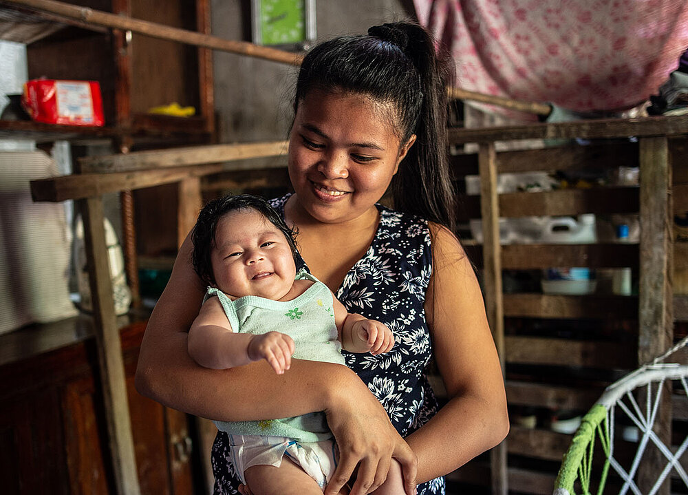 Philippinerin mit Baby im Arm