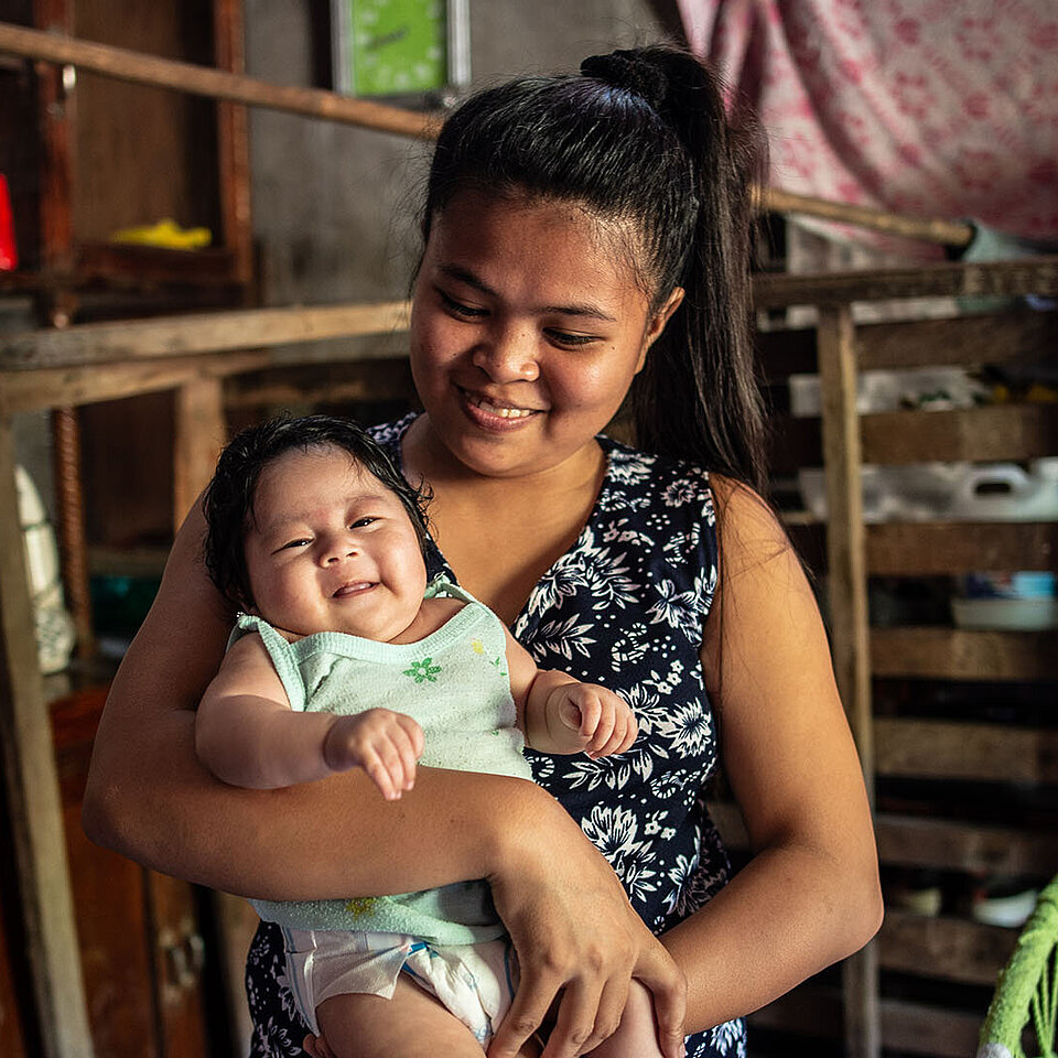 Philippinerin mit Baby im Arm