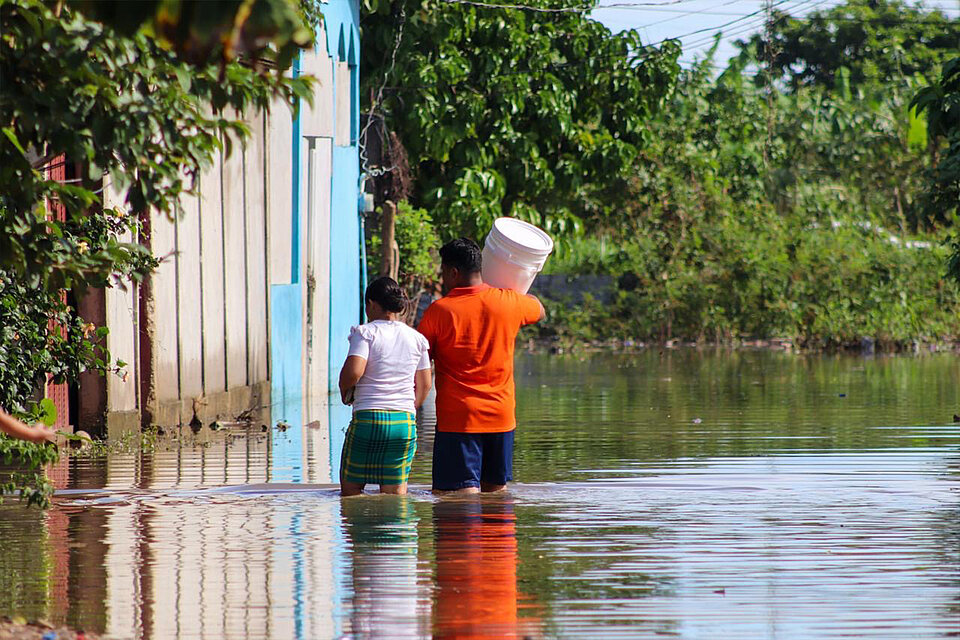 Zwei Menschen waten durch überflutetes Gebiet in Honduras 