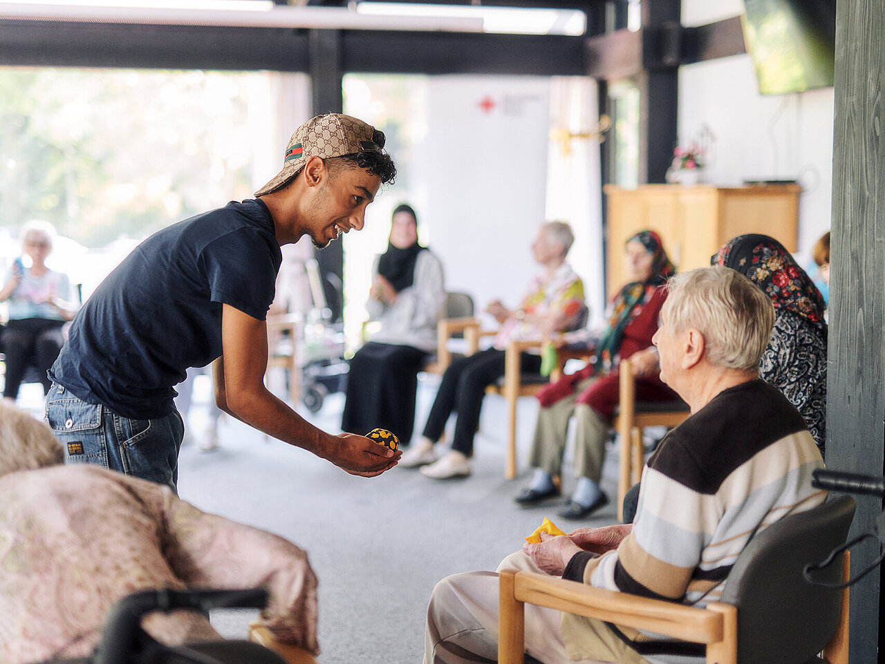 Junger Mann reicht Senior einen Ball