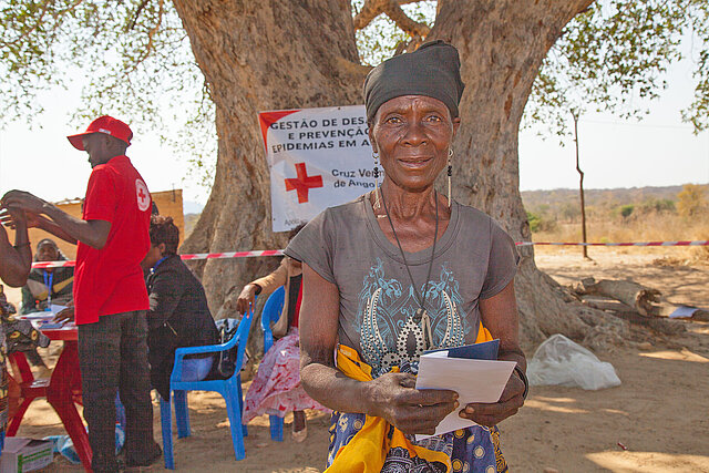 Frau erhält durch das Rote Kreuz Bargeldhilfe in Angola