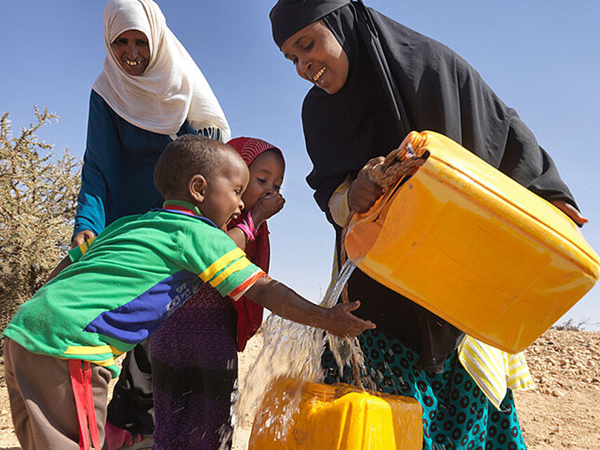 somalische Kinder freuen sich über Wasser aus Kanister