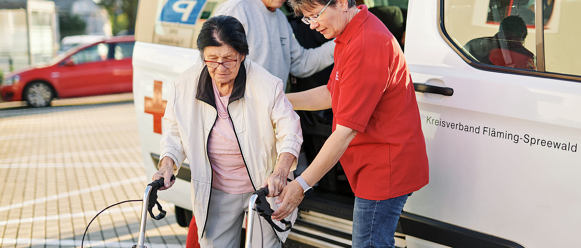 Fahrdienst Seniorin steigt aus DRK-Fahrdienst-Fahrzeug aus