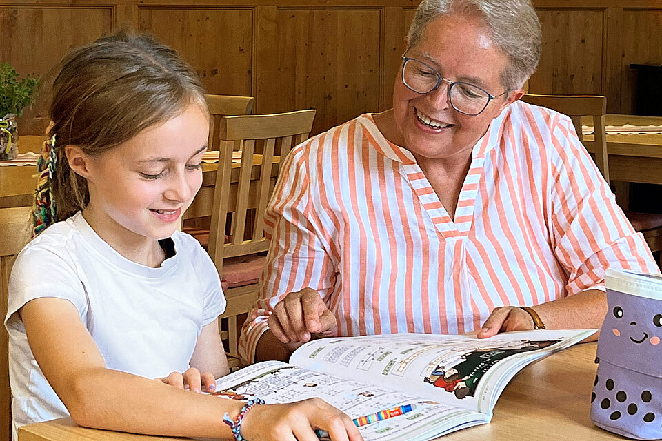 Seniorin liest mit Mädchen