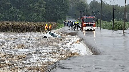 Rettungskräfte und versinkendes Auto