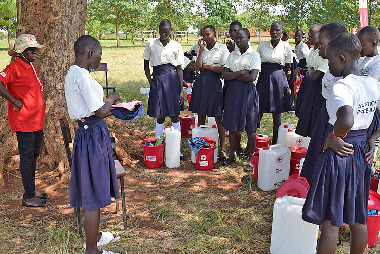 Frauen und Mädchen in Uganda bei der Verteilung von Hygieneartikeln durch das Rote Kreuz 