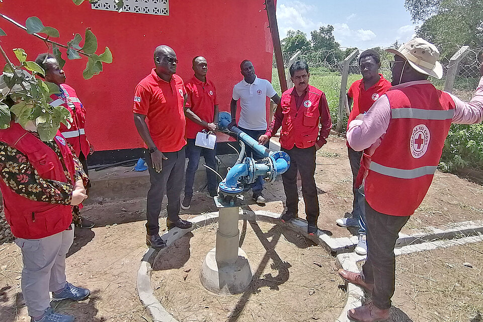 Rotkreuzteam bei der Begutachtung einer Wasserpumpe in Uganda 