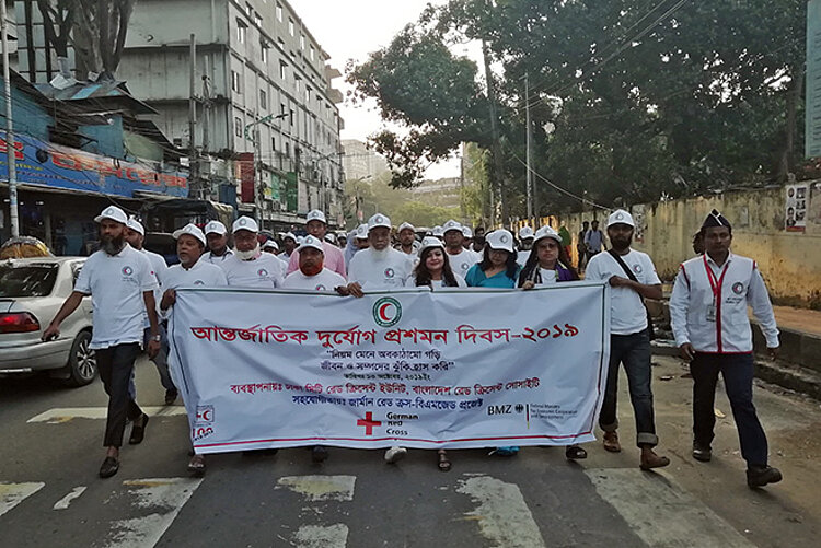 Foto: Menschen aus Bangladesch mit Banner auf der Straße
