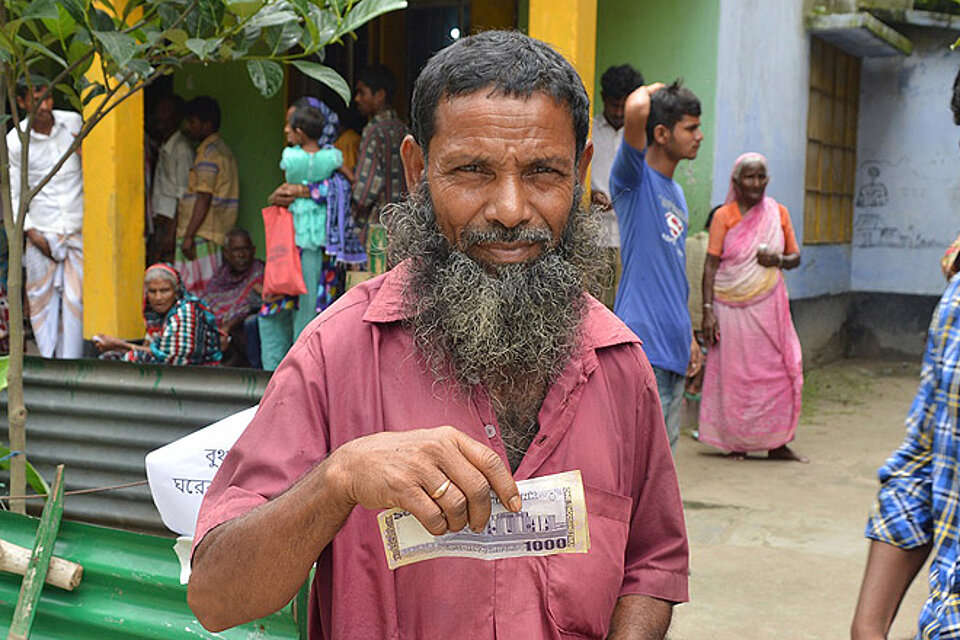 Ein bengalischer Mann mit einem Geldschein 