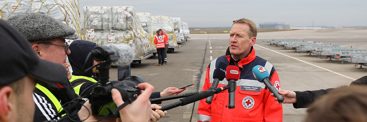 DRK-Generalsekretär Christian Reuter DRK-Generalsekretär Christian Reuter steht in DRK-Einsatzkleidung im Freien und wird interviewt