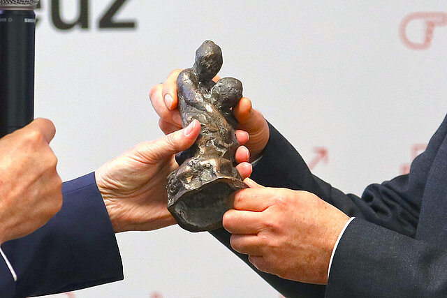 Hände überreichen von Bruno Raetsch geschaffene Bronze-Skulptur des Castiglione-Preises