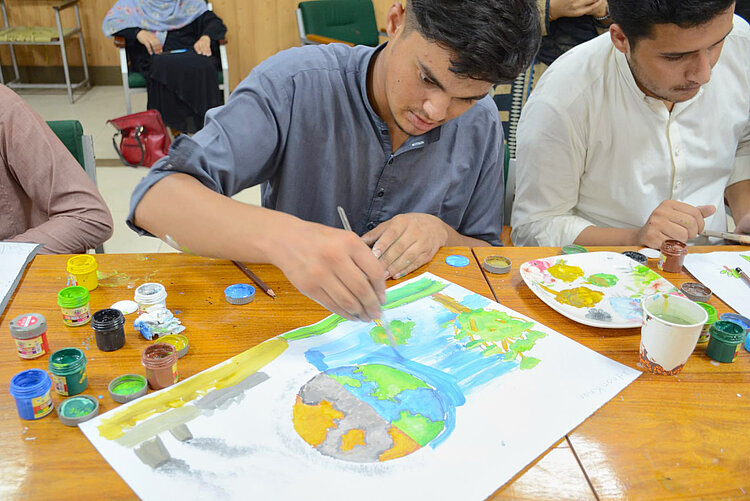 Jugendlicher malt die Erde