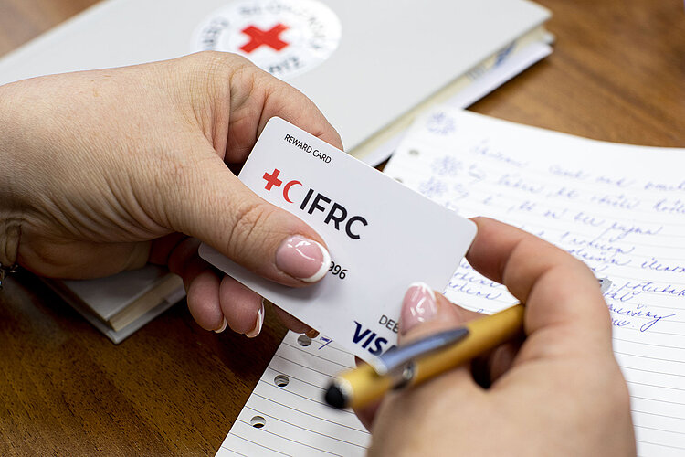 IFRC-Visa-Karte in Hand einer Mitarbeiterin